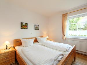 1 dormitorio con 2 camas y ventana en Apartment Osterriede by Interhome, en Norddeich