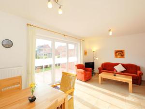 - un salon avec un canapé rouge et une table dans l'établissement Apartment Osterriede by Interhome, à Norddeich