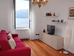 a living room with a red couch and a window at Apartment Piazzetta by Interhome in Maccagno Inferiore
