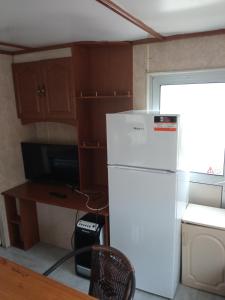 a kitchen with a white refrigerator and a desk at Domki Gucio i Maja in Grodzisk Mazowiecki