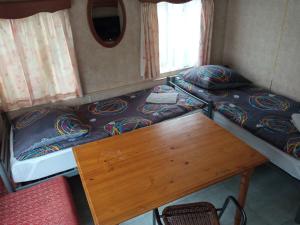 a room with two bunk beds and a wooden table at Domki Gucio i Maja in Grodzisk Mazowiecki