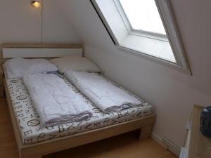 ノルトダイヒにあるApartment Schwalbennest III by Interhomeの窓付きの客室の小さなベッド1台分です。