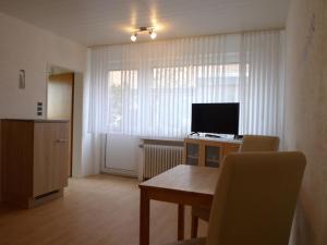 een kleine woonkamer met een tafel en een televisie bij Apartment Schwalbennest II by Interhome in Norddeich