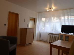 een woonkamer met een groot raam en een televisie bij Apartment Schwalbennest II by Interhome in Norddeich