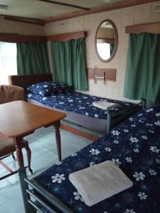 Zimmer mit 2 Betten, einem Tisch und einem Spiegel in der Unterkunft Domki Gucio i Maja in Grodzisk Mazowiecki