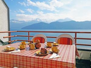 una mesa con comida y utensilios en la parte superior de un balcón en Apartment Seeblick by Interhome, en Weggis