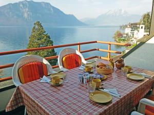 una mesa en un balcón con vistas al agua en Apartment Seeblick by Interhome en Weggis