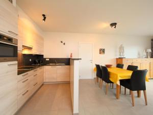cocina y comedor con mesa amarilla y sillas en Apartment Residentie Greens by Interhome, en Mispelburg