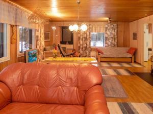 a living room with a leather couch and a table at Holiday Home Tulisuontie a by Interhome in Ruka