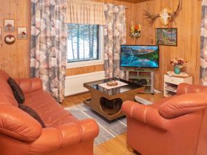 a living room with two couches and a tv at Holiday Home Tulisuontie a by Interhome in Ruka
