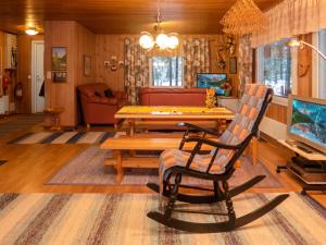 a living room with a table and a chair at Holiday Home Tulisuontie a by Interhome in Ruka
