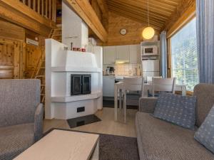 uma sala de estar com lareira e uma cozinha em Holiday Home Vuosselinkulma 2 by Interhome em Ruka