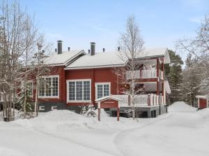 レヴィにあるHoliday Home Kätkänlinna a2 by Interhomeの地面雪の赤い家