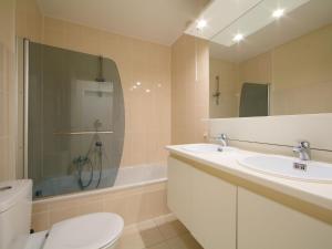 een badkamer met 2 wastafels, een toilet en een bad bij Apartment Residentie Havenhuys-1 by Interhome in Bredene