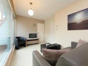 een woonkamer met een bank en een televisie bij Apartment Residentie Havenhuys-1 by Interhome in Bredene