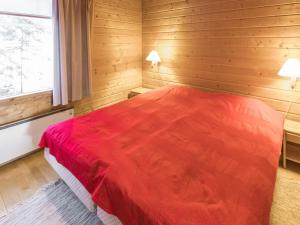 ユッラスヤルヴィにあるHoliday Home Tunturinvieri k2 by Interhomeの木製の部屋に赤いベッドが備わるベッドルーム1室