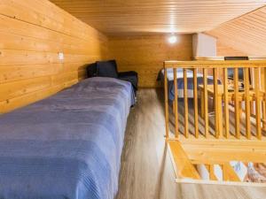 ユッラスヤルヴィにあるHoliday Home Tunturinvieri k2 by Interhomeの木造キャビン内のベッド1台が備わるベッドルーム1室を利用します。