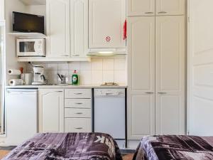 レヴィにあるHoliday Home Levi star 1503 by Interhomeの白いキャビネットと食器洗い機付きのキッチンが備わります。