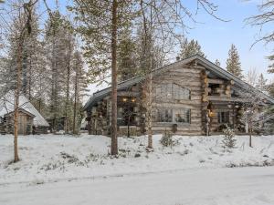 a log cabin in the woods in the snow at Holiday Home Samruam a kelohuvila by Interhome in Salla