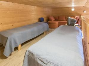 ユッラスヤルヴィにあるHoliday Home Tunturinvieri k3 by Interhomeのベッド2台とソファが備わる客室です。