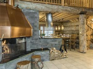 a kitchen with a large fireplace and a stove at Holiday Home Samruam a kelohuvila by Interhome in Salla