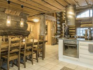 a kitchen with a table and chairs and a stove at Holiday Home Samruam a kelohuvila by Interhome in Salla