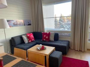 a living room with a blue couch and a table at Holiday Home Tahkovuori chalet b 406 by Interhome in Tahkovuori