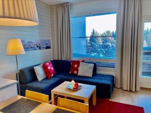 a living room with a blue couch and a table at Holiday Home Tahkovuori chalet b 406 by Interhome in Tahkovuori
