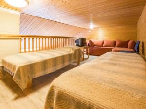 ユッラスヤルヴィにあるHoliday Home Tunturinvieri k1 by Interhomeのベッド2台とソファが備わるホテルルームです。