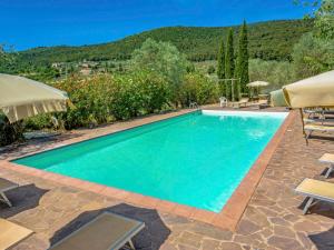 a swimming pool with chairs and umbrellas at Apartment L'Erika by Interhome in Cetinale