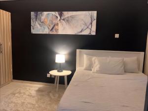 Un dormitorio con una cama y una mesa con una lámpara. en Peaceful and Lovely 1 bedroom with a city view., en Nairobi