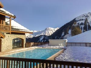 a swimming pool in the snow next to a house at Apartment Les Alpages du Corbier-1 by Interhome in Le Corbier