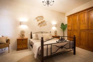 a bedroom with a bed and a dinosaur on the wall at Sweet Life Gozo in Santa Luċija