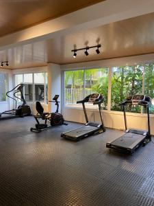 a gym with several treadmills and elliptical machines at Portal das Palmeiras 2 in Ubatuba