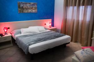 a bedroom with a large bed with two lamps on tables at Pensione degli Ulivi in Porto SantʼElpidio