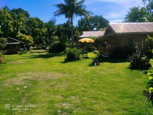 a yard in front of a house with an umbrella at Shirley's Cottage - Pamilacan Island in Pamilacan