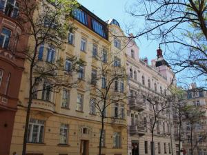 プラハにあるApartment Manes Apartment by Interhomeの目の前に木々が植えられた大きな黄色の建物