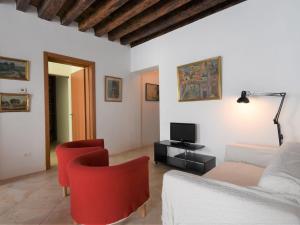 ヴェネツィアにあるApartment Casanas-2 by Interhomeのリビングルーム(ソファ、赤い椅子付)