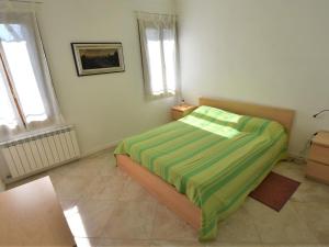a bedroom with a bed with a green blanket on it at Apartment Casanas-2 by Interhome in Venice