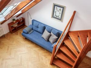 un sofá azul en una sala de estar junto a una escalera en Apartment O21 by Interhome, en Praga