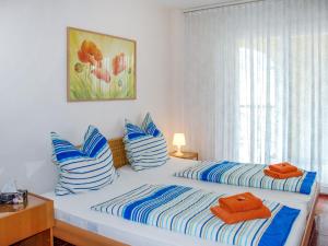 a bedroom with two beds with blue and white striped pillows at Apartment Residenza Moro by Interhome in Ascona