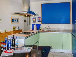 La cuisine est équipée d'un comptoir bleu et d'un évier. dans l'établissement Apartment Residenza Moro by Interhome, à Ascona