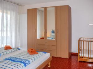 - une chambre avec 2 lits et une armoire en bois dans l'établissement Apartment Residenza Moro by Interhome, à Ascona