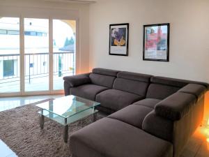 ein Wohnzimmer mit einem Sofa und einem Glastisch in der Unterkunft Apartment Residenza Moro by Interhome in Ascona