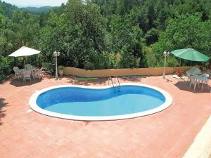 basen na patio ze stołem i parasolem w obiekcie Holiday Home Can Trullas by Interhome w mieście Viladecaballs