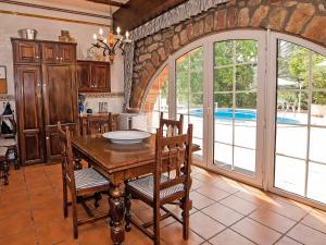 uma cozinha com uma mesa de madeira com cadeiras e uma porta aberta em Holiday Home Can Trullas by Interhome em Viladecaballs