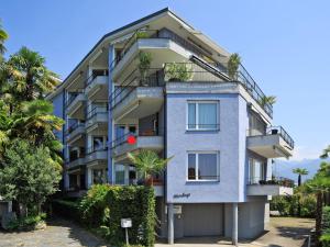 ein blaues Gebäude mit Bäumen davor in der Unterkunft Apartment Junior Suite Modern-20 by Interhome in Ascona