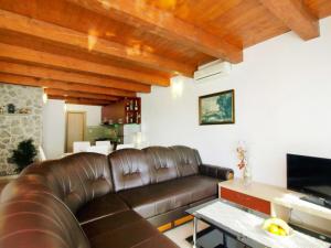 a living room with a leather couch and a television at Holiday Home Villa Sandra by Interhome in Kruševo