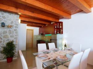 jadalnia ze szklanym stołem i białymi krzesłami w obiekcie Holiday Home Villa Sandra by Interhome w mieście Kruševo