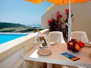 a table with a bottle of wine and a bowl of fruit at Apartment T2 by Interhome in Sintra